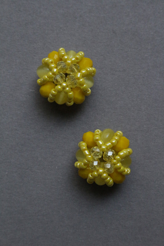 Pair of yellow beaded elements on a grey background